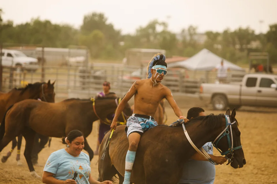 A rider wearing a blue face covering sits on a horse at the relay grounds.