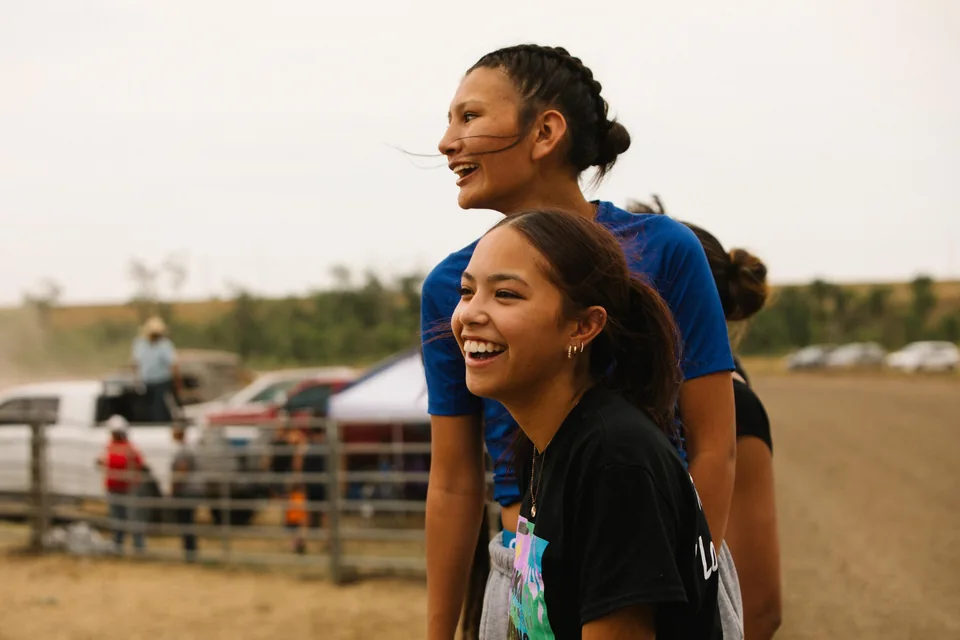 Two young spectators smile as they watch the relay races.