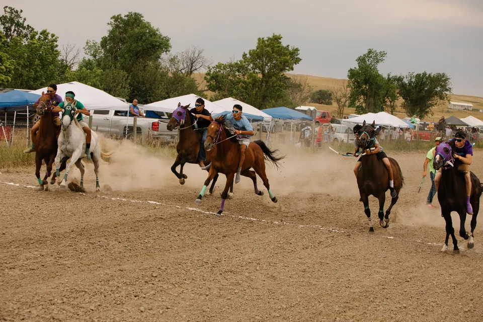 Bareback riders spread across the track in front of spectators’ tents.