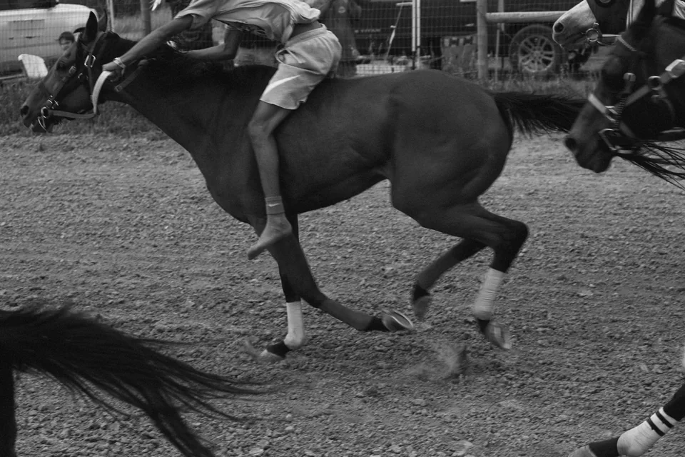 Black-and-white close-up of a bareback rider and galloping horse.